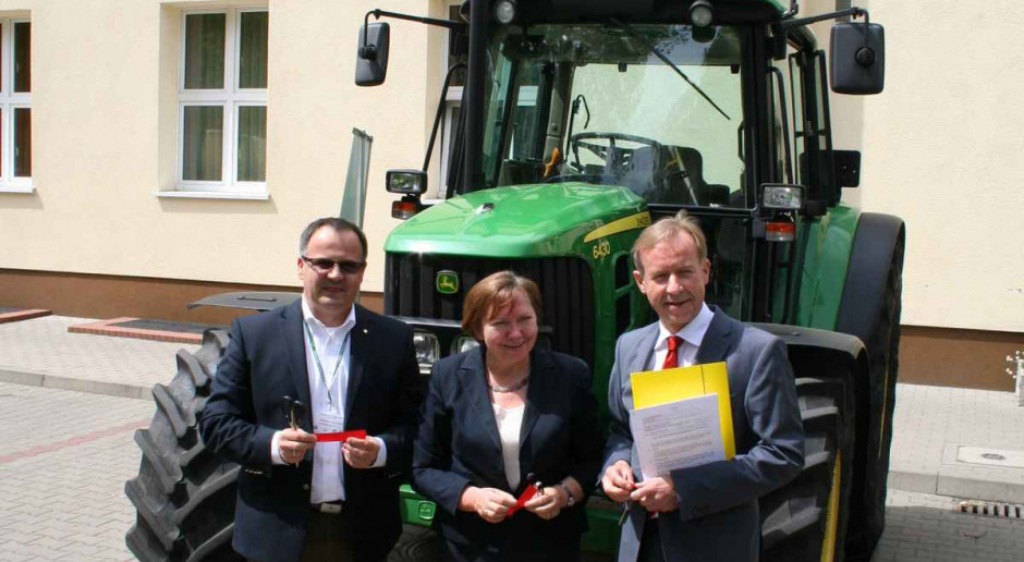 Na tle ciągnika przekazanego Uczelni stoją (od lewej): Mirosław Leszczyński prezes zarządu dyrektor generalny John Deere Polska, prof. dr hab. Monika Kozłowska prorektor ds. studiów Uniwersytetu Przyrodniczego w Poznaniu oraz prof. dr hab. Jacek Przybył dyrektor instytutu inżynierii biosystemów Uniwersytetu Przyrodniczego w Poznaniu. Ciągnik John Deere dla UP w Poznaniu