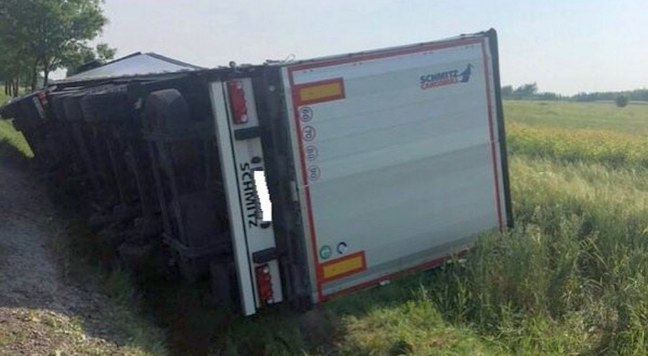 Pojazd wraz z naczepą wyładowaną ciągnikami wjechał do rowu i wywrócił się na bok, fot. Policja Pijani wieźli tirem ciągniki do Włoch, wyprawę zakończyli w rowie