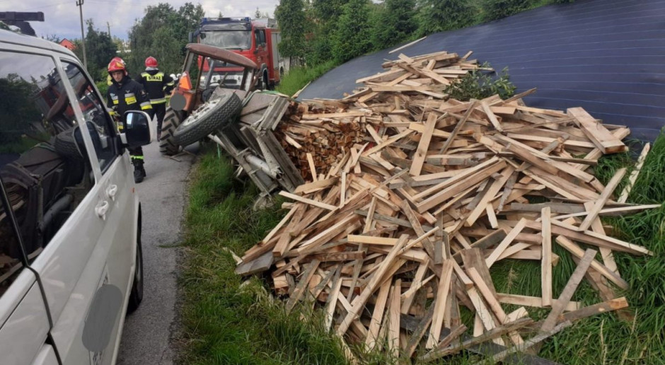 Pod ładunkiem drewna został uwięziony pasażer jadący na wozie, Foto: PSP Myślenice Wywrócił się wóz za ciągnikiem, poszkodowany pasażer